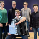 Quirin Meinersmann nach bestandener D3-Prüfung am Akkordeon – gemeinsam mit den Juroren der Leistungsprüfung und seiner Lehrerin Sonja Zimmermann-Wagner (v.l.: Sonja Zimmermann-Wagner, Christoph Peters, Quirin Meinersmann, Katrin Masius und Stefan Bauer)
