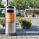 Die Mülleimer in der Innenstadt sind nun mit orangenen Aufklebern ausgestattet.