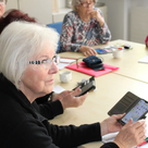 Ehrenamtlichen Trainer helfen, Senioren den Umgang mit dem Smartphone zu erleichtern.

