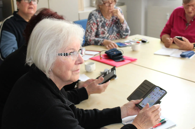 Ehrenamtlichen Trainer helfen, Senioren den Umgang mit dem Smartphone zu erleichtern.