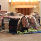 So lässt es sich aushalten: Die Kinder lauschen in ihrer selbstgebauten Bücherhöhle der spannenden Geschichte