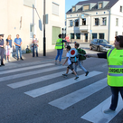 Schulweghelfer helfen Kindern wie hier an der Scheyerer Straße beim Überqueren der Straße.