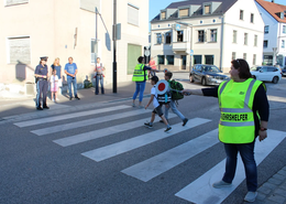 Schulweghelfer helfen Kindern wie hier an der Scheyerer Straße beim Überqueren der Straße.