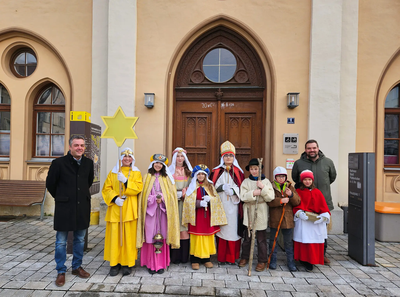 Bürgermeister Thomas Herker gemeinsam mit den Sternsingern und Stadtrat Richard Fischer vor dem Rathaus.
