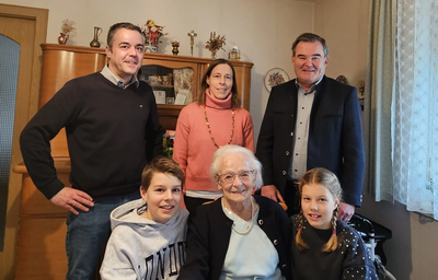 Das Esszimmer war gefüllt mit Gratulanten: hinten v.l.n.r. Bürgermeister Thomas Herker, Enkelin Anna Kauf, Landrat Albert Gürtner, vorne: Maria Bäuml mit ihren Urenkeln Benedikt und Emma. 