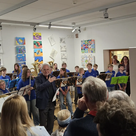 Foto 1: Reinhard Haiplik eröffnete die Vernissage; im Hintergrund die Bläserklasse der Georg-Hipp-Realschule. 