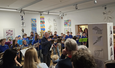 Foto 1: Reinhard Haiplik eröffnete die Vernissage; im Hintergrund die Bläserklasse der Georg-Hipp-Realschule. 