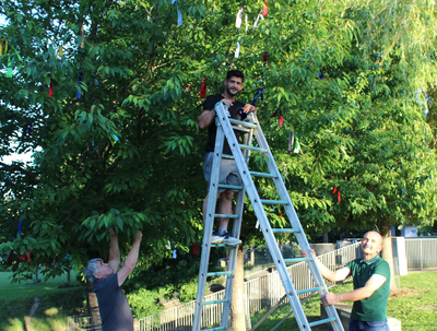 Sie haben den Baum der Religionen mit bunten Bändern geschmückt (von links): Shemsi und Hajdin Haziri sowie Ardian Ndreka. 