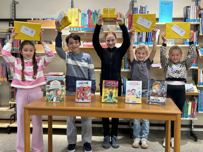 Die Kinder präsentieren ihre Preisbücher und Gewinne 