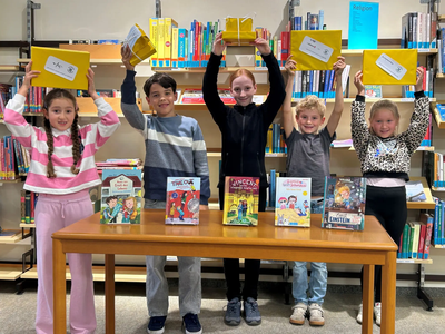 Fünf der neun Gewinner präsentieren ihre Preisbücher und Gewinne der Lese-Wunder-Tüten-Aktion.