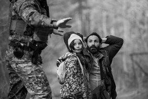 Schwarz-weiß Foto, Soldat, Mann und Kind zu sehen in einem Waldstück