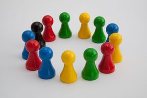 verschiedenfarbige Spielfiguren im Kreis aufgestellt