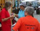 13.06.2015: Wochenmarkt Pfaffenhofen an der Ilm: Pfaffenhofen ist bunt!: Manfred Mensch Mayer überreicht Monika Schratt 100 HALLERTAUER als Spende zur Mitfinanzierung der bunten T-Shirts mit der Stickerei 