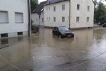 Überschwemmte Straße mit einem Auto beim Starkregenereignis im August 2023.