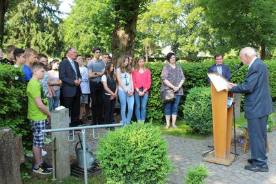 Bei der Aktion „Blumen gegen das Vergessen“ auf dem Pfaffenhofener Soldatenfriedhof: Nikolaus Ostermeier mit 2. Bürgermeister Albert Gürtner, Landrats-Stellvertreter Anton Westner und Schülern und Lehrern der Mittelschule Pfaffenhofen.