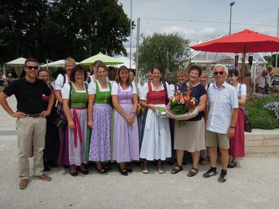 Veronika Fleißner (1. Reihe, 3. v.r.) und weitere Mitglieder des Trachtenvereins beim Fototermin mit Erstem Bürgermeister Thomas Herker (1. Reihe, l.) und den Gartenschau-Geschäftsführern Eva Linder (mit Blumenstrauß) und Walter Karl (1. Reihe, r.)