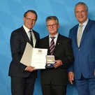 Bildtext: Innenminister Joachim Herrmann (rechts) überreichte Florian Weiß die Ehrenmedaille für besondere Verdienste um den Sport in Bayern; BLSV-Präsident Jörg Ammon (links) gratulierte. Foto: Bruckmeier