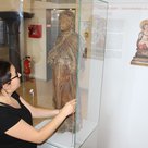 Eine ungewöhnliche Marienfigur – eine schwangere Madonna – ist eines der Exponate in der Ausstellung „Glaube – Liebe – Gute Hoffnung“, die die städtische Mitarbeiterin Ines Zirngibl hier aufbaut.