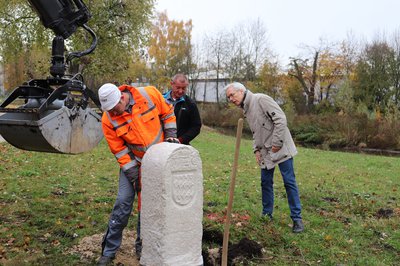 Mitarbeiter der Stadtwerke Pfaffenhofen und Stadtarchivar Andreas Sauer beim Aufstellen einer Replik eines Burgfriedensteins