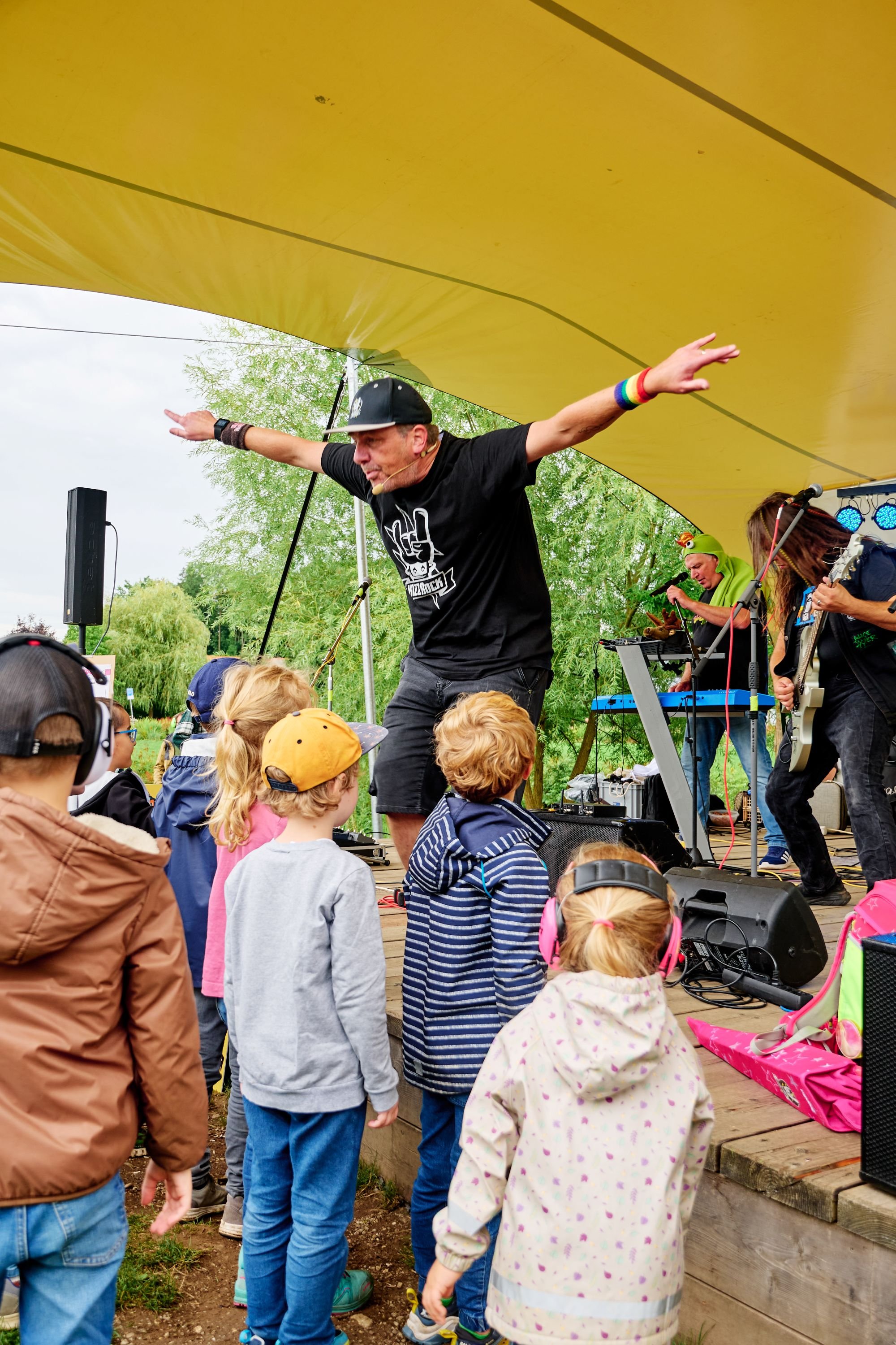 Mann auf Bühne und Kinder vor der Bühne