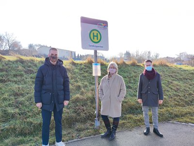 Matthias Stocker (Stadtwerke Pfaffenhofen), Anita Hörskens und Alexander Schneider (Stadtwerke Pfaffenhofen) vor der neuen Haltestelle Sandkrippenfeld.