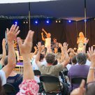 Im Innenhof des Landratsamtes heben viele Menschen die Hände, weil die Saragossa Band einen der bekanntesten Songs singt. Die Mitglieder der Gruppe tanzen und singen auf der Bühne. Die Kleidung hat einen karibischen Touch.