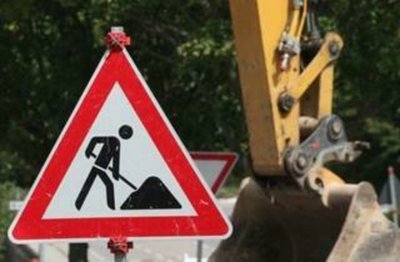 Ein Baustellen-Verkehrsschild, daneben eine Baggerschaufel