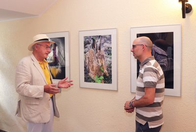 Ernst Hillisch und Philipp Hayer, Vorstand der vhs-Fotofreunde vor den drei Bildern im Fiyer im Haus der Begegnung. 