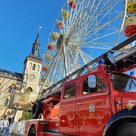 Die "Oide Lies", der rote Feuerwehr-Oldtimer der Feuerwehr Pfaffenhofen auf dem Hauptplatz. Dahinter das Rathaus und das Riesenrad.