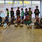 Skateboard-Workshopleiter mit 13 Kindern auf Skaterampe in der Skatehalle