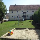 Spielplatz mit Sandkasten, Schaukeln und Turm mit Rutsche