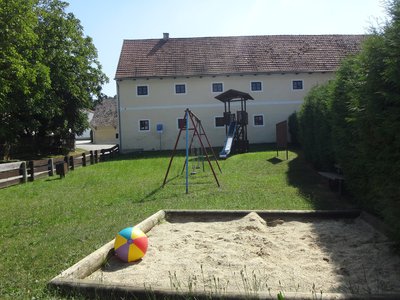 Spielplatz mit Sandkasten, Schaukeln und Turm mit Rutsche