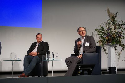 Berufsmäßiger Stadtrat Florian Erdle (rechts) belebt eine Diskussion zur Live-Übertragung gemeindlicher Sitzungen auf der KOMMUNALE 2021.