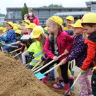 Kindergartenkinder beim ersten Spatenstich für den Erweiterungsbau des städtischen Kindergartens Maria Rast im Juli 2021. Bis September 2023 wird die Einrichtung um einen Hort, zwei Krippengruppen und weitere Räume zu einem „Haus für Kinder“ erweitert.