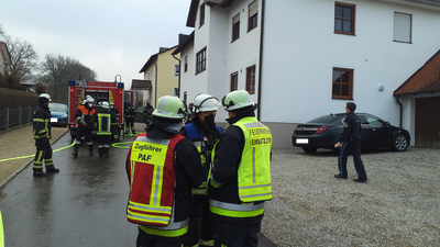 Feuerwehr im Einsatz auf einer Stra´ße vor einem Haus