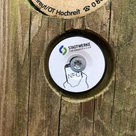 NFC Kontaktplättchen an einem Holzpfahl in Großaufnahme