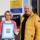 Geschäftsstellenleiterin Beate Mayr und 1.MTV-Vorsitzender Helmut Reiter nehmen die 150 Hallertauer erfreut in Empfang.