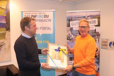 Bürgermeister Thomas Herker überreicht Roland Dörfler ein Geburtstagspräsent