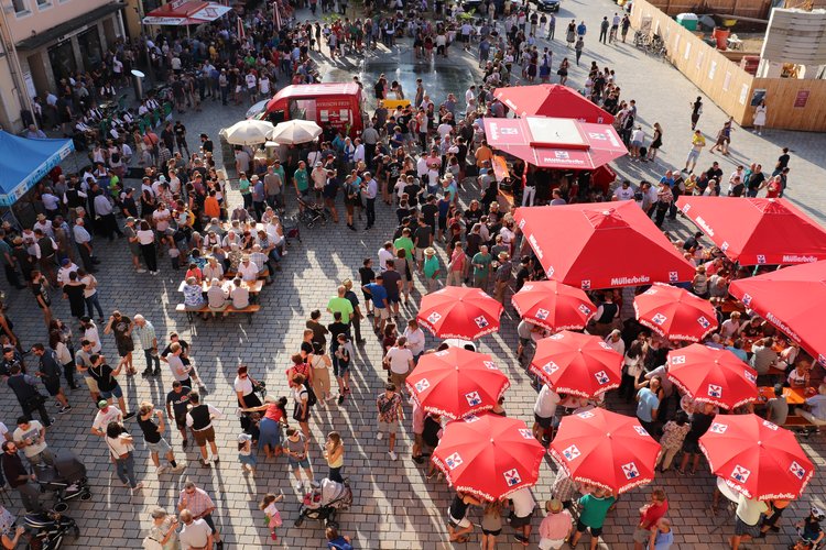 Platz vorm Rathaus voller Menschen mit Sonnenschirmen bei der Bierprobe 2019.