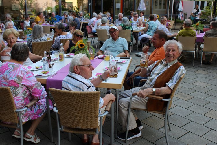 Senioren sitzen im Innenhof zusammen