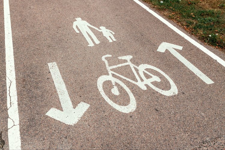 Zeichen für einen geteilten Weg von Fahrradfahrern und Fußgängern auf Teer.