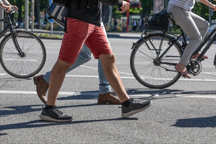 Fahrradfahrer und Fußgänger auf einer Straße.