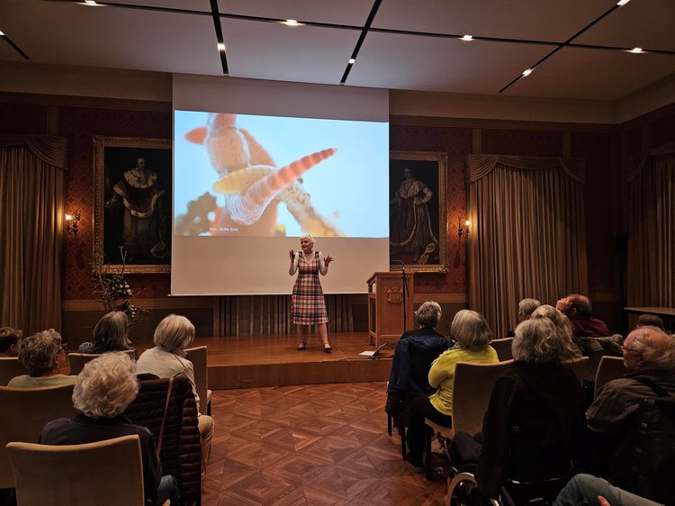Gefüllter Festsaal mit Leinwand