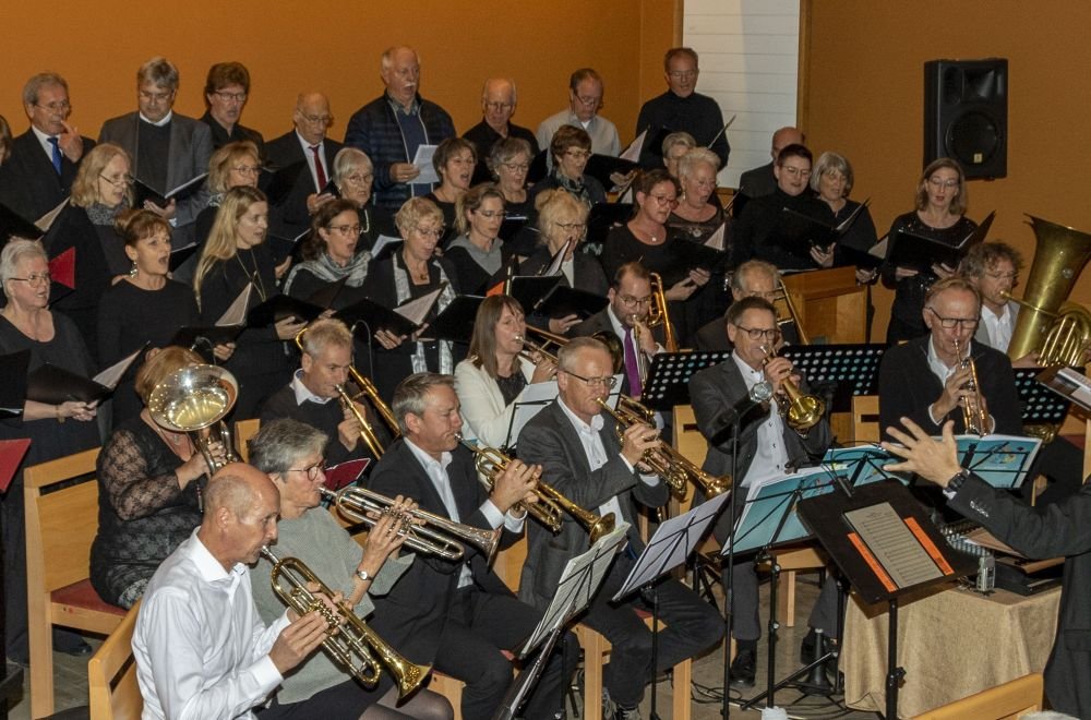 Zahlreiche Männer und Frauen singen und spielen Instrumente