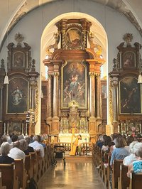 Spitalkirche in der Andy Aquarius auf seiner keltischen Harfe spielt