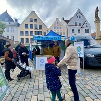 Menschen versammeln sich bei dem PAFundDU-Infostand und führen Gespreäche.