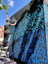Künstler bemalt großen Würfel am hauptplatz