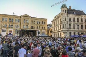 Blick auf Haus der Begegnung mit hunderten Menschen vor einer Bühne