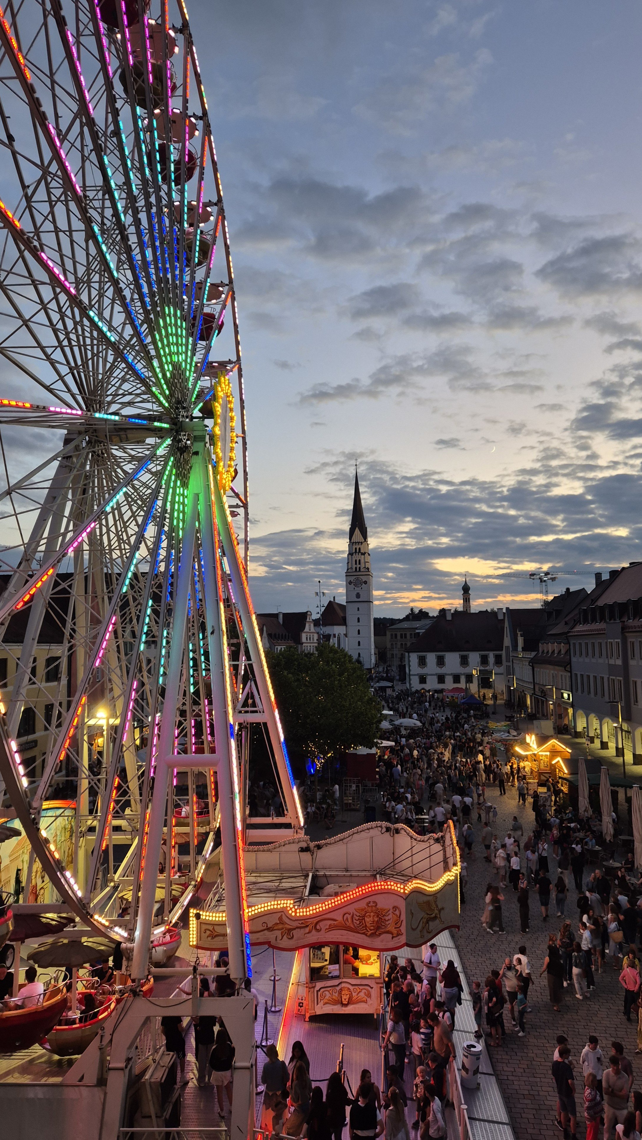 Blick vom Rathausbalkon auf Hauptplatz mit Riesenrad und vielen Menschen