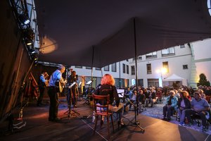 Foto von Musikern auf der Bühne mit Blickrichtung ins Publikum im Innenhof des Landratsamts